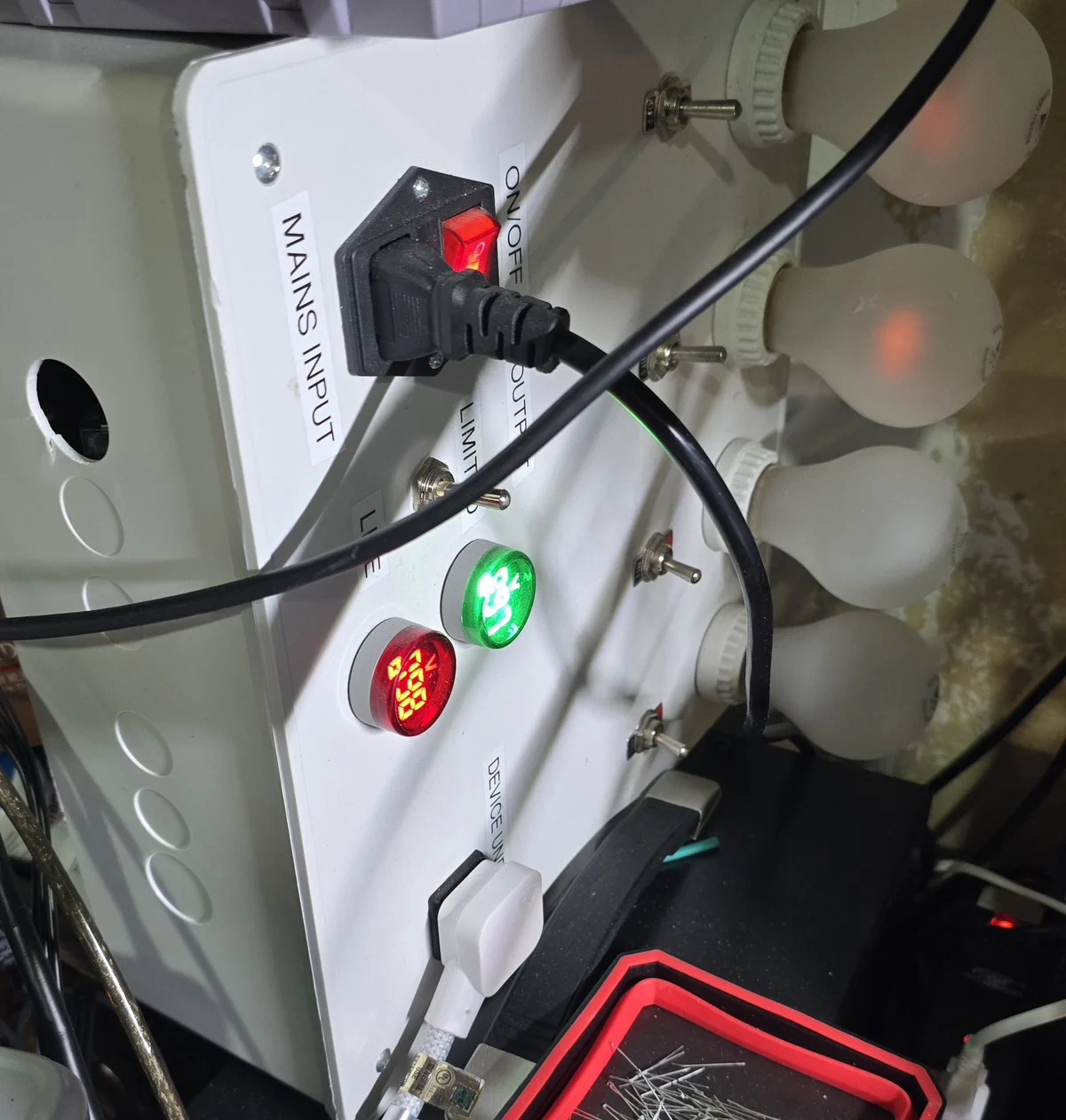 The dim bulb tester with two bulbs switched in, each glowing faintly orange, and two bulbs dark.