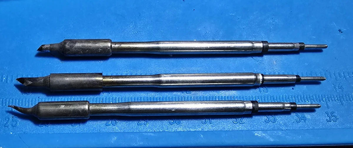 Three JBC-style soldering tips laid out: a chisel C2, a knife tip and a bent conical J-style.
