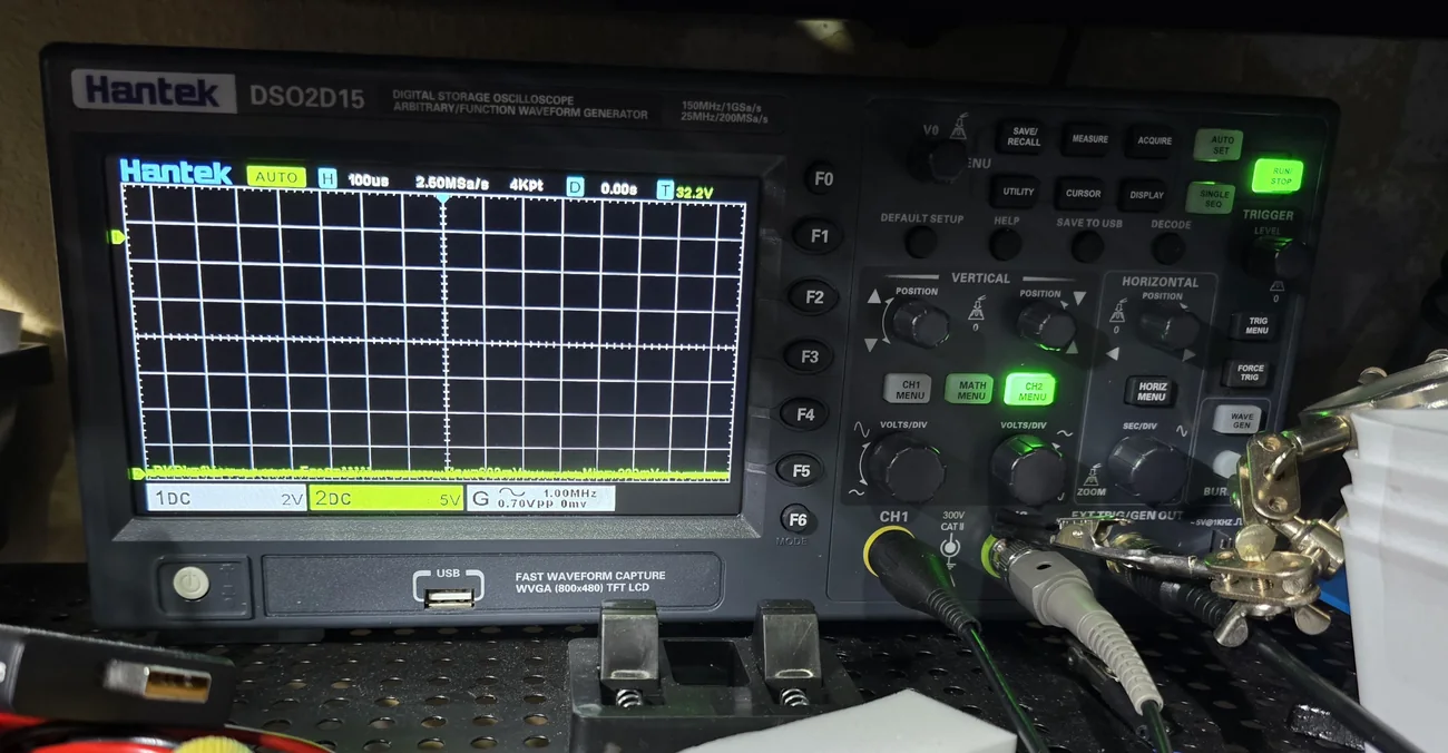 A benchtop digital oscilloscope powered on at a workbench.