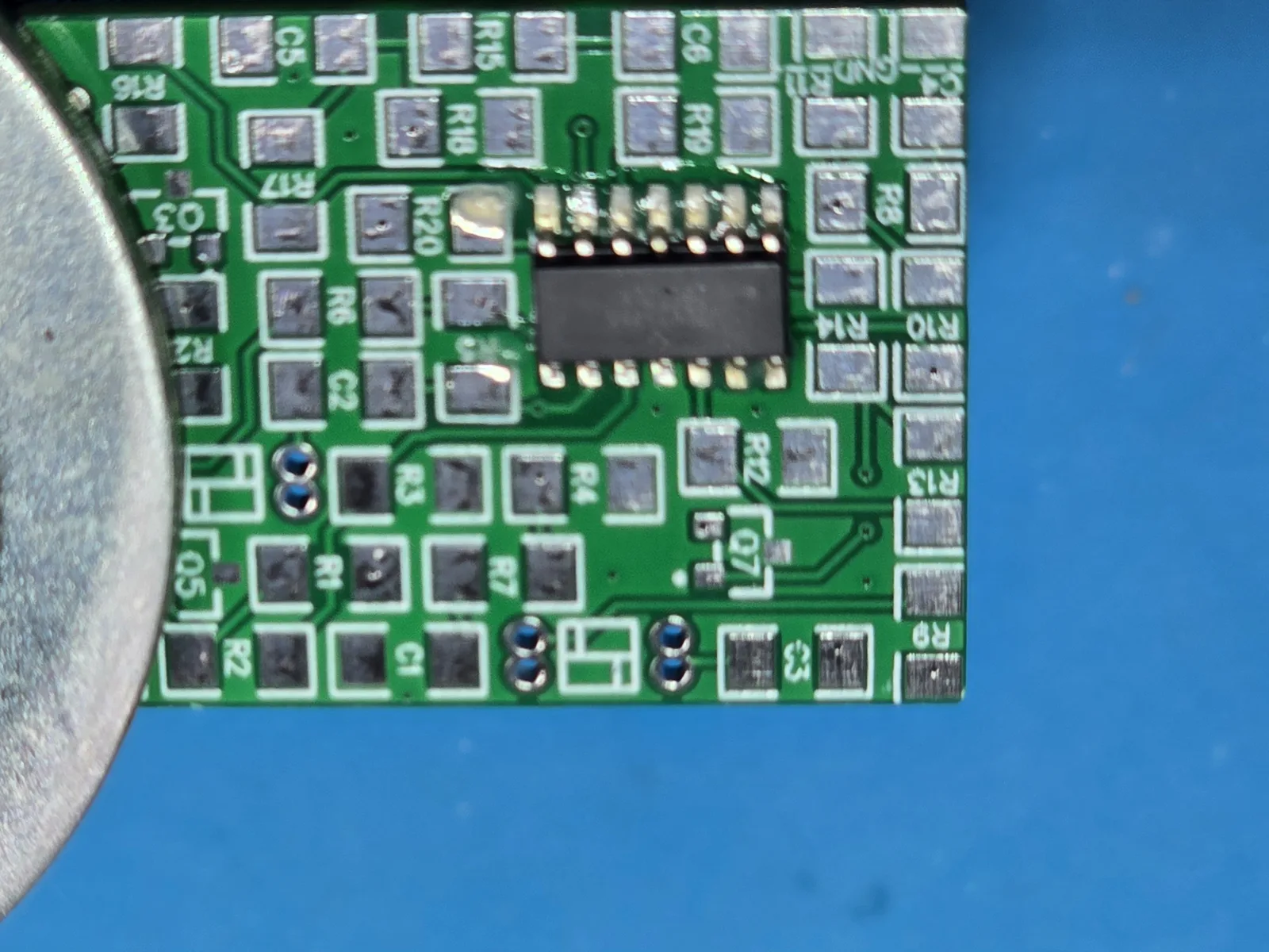 Close-up of the SOIC-14 op-amp seated on its footprint with flux visible around the pins, before cleaning.