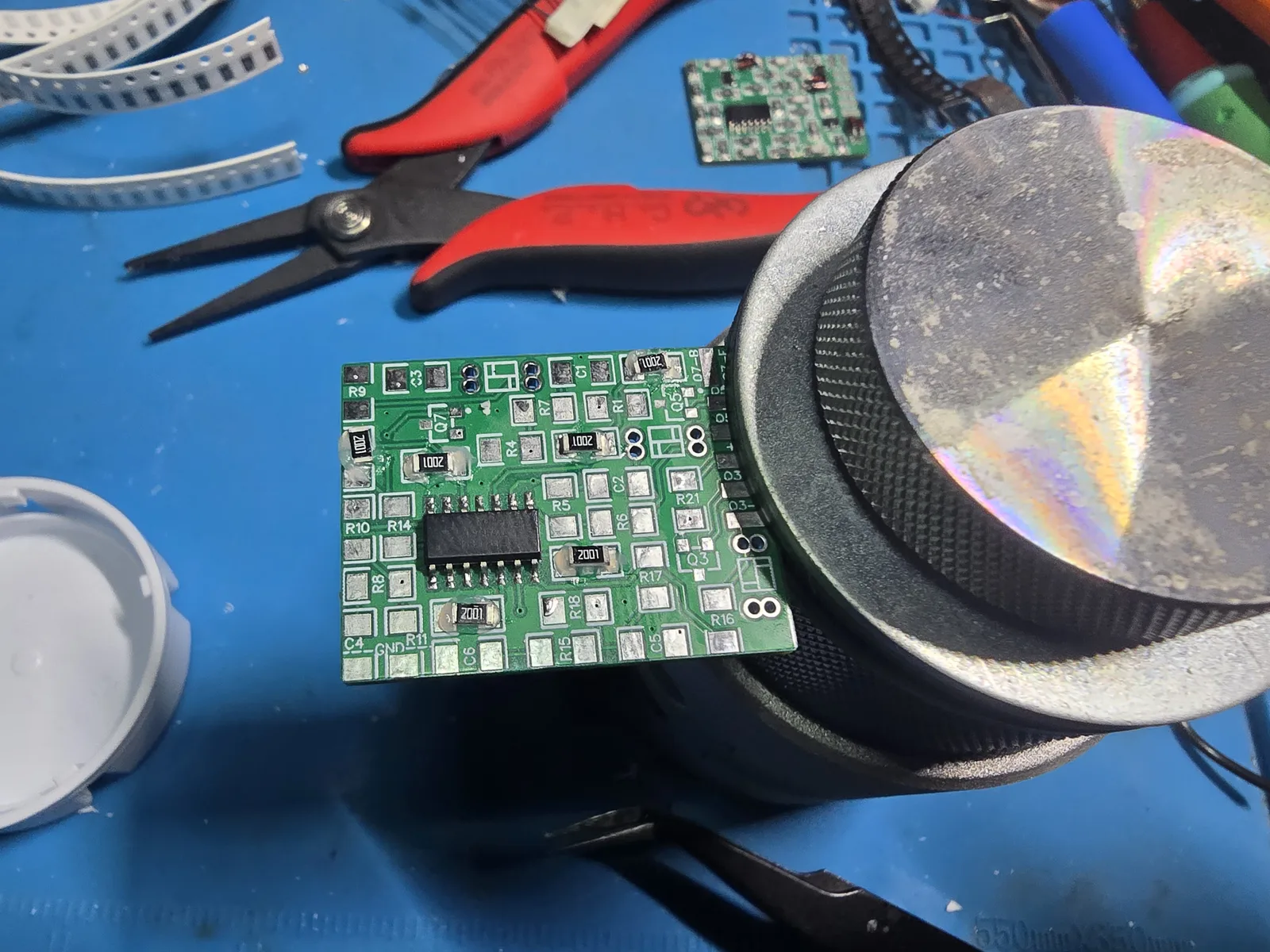 The mod board with the op-amp fitted and several 2 kilohm 1206 resistors placed on their pads ready to solder.