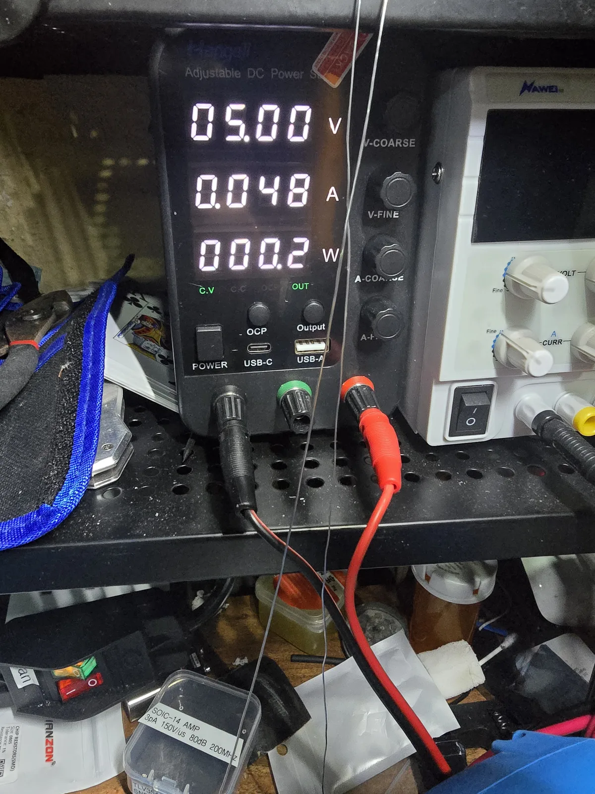 Bench power supply display showing 5.00 volts, 0.048 amps and 0.2 watts in constant-voltage mode while powering the mod board.