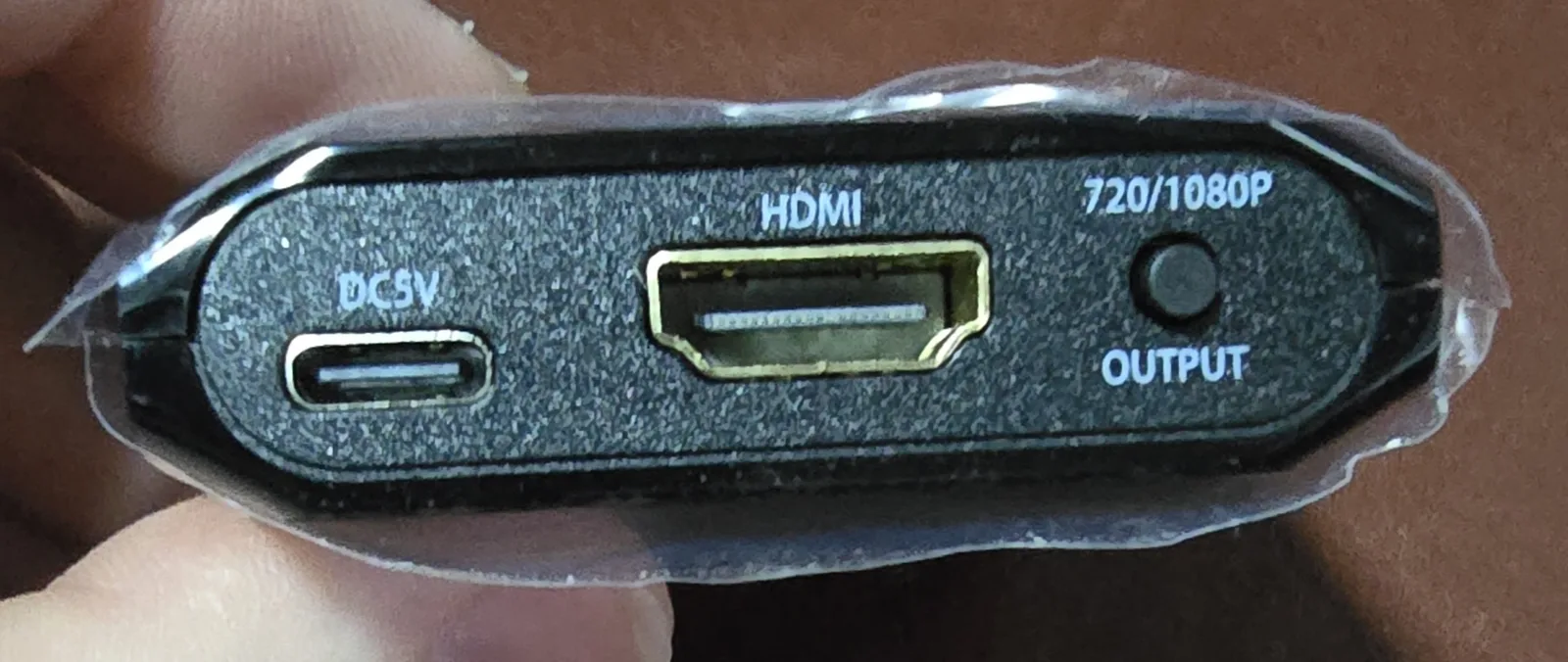 Output side: USB-C 5V power port, HDMI output, and a 720p/1080p output button