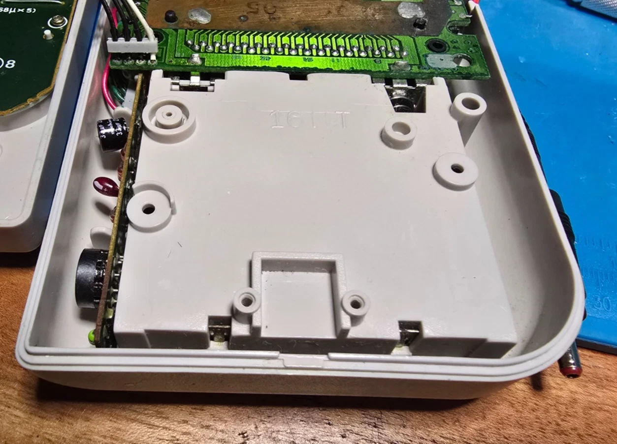 Inside the DMG shell, the plastic housing around the headphone jack before any trimming