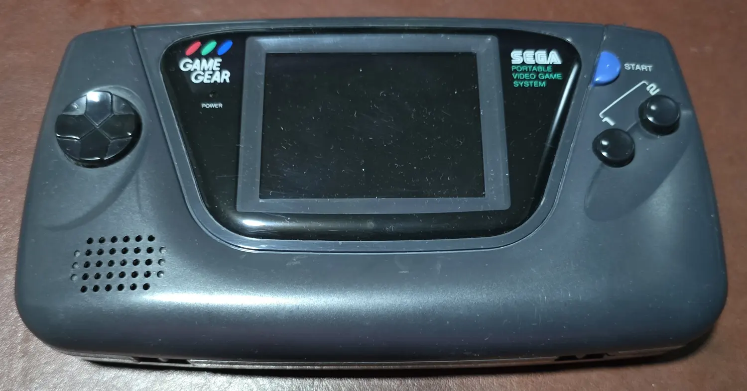 Front of the all-original Sega Game Gear included in this listing, powered off, with its original screen bezel and controls