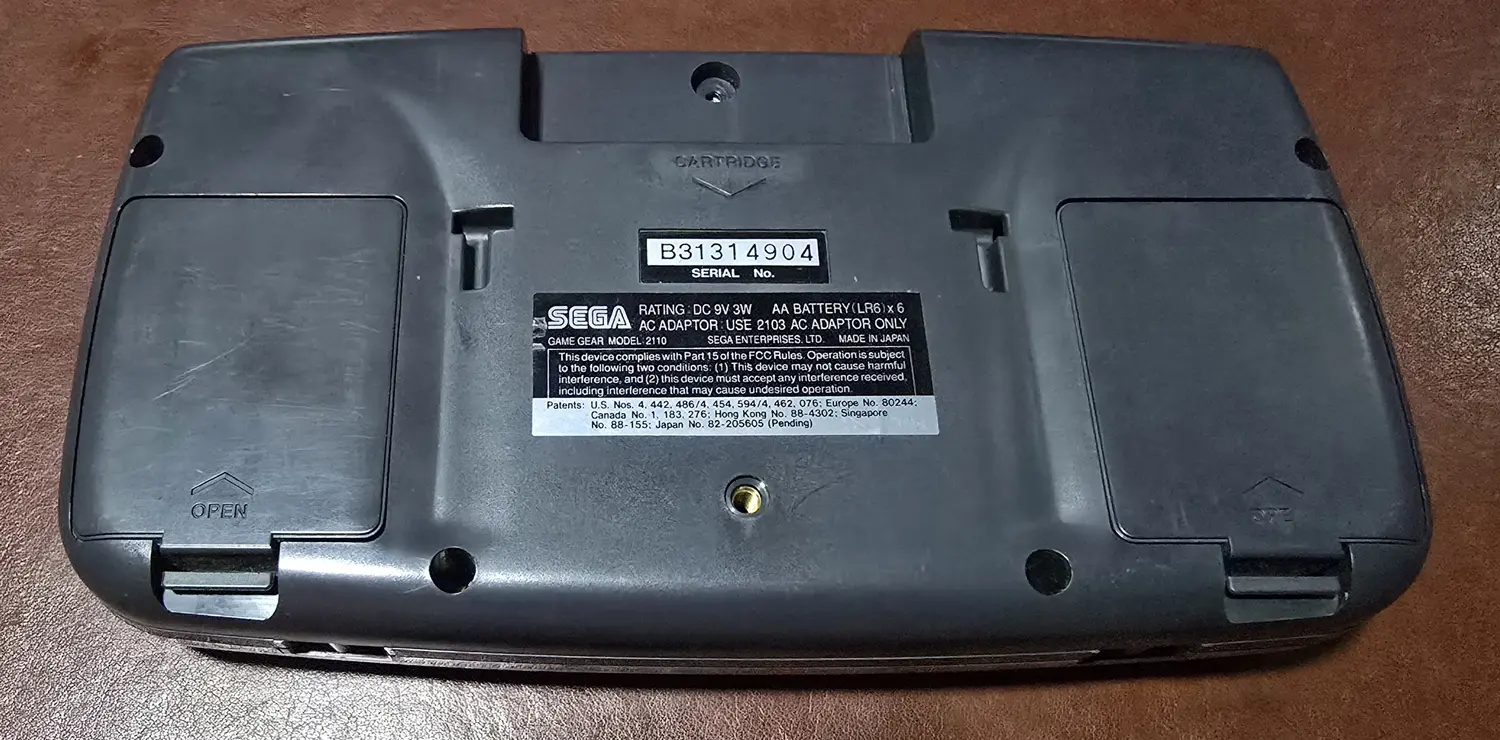 Back of the Game Gear with both original battery doors fitted, serial B31314904 and MADE IN JAPAN legible on the label