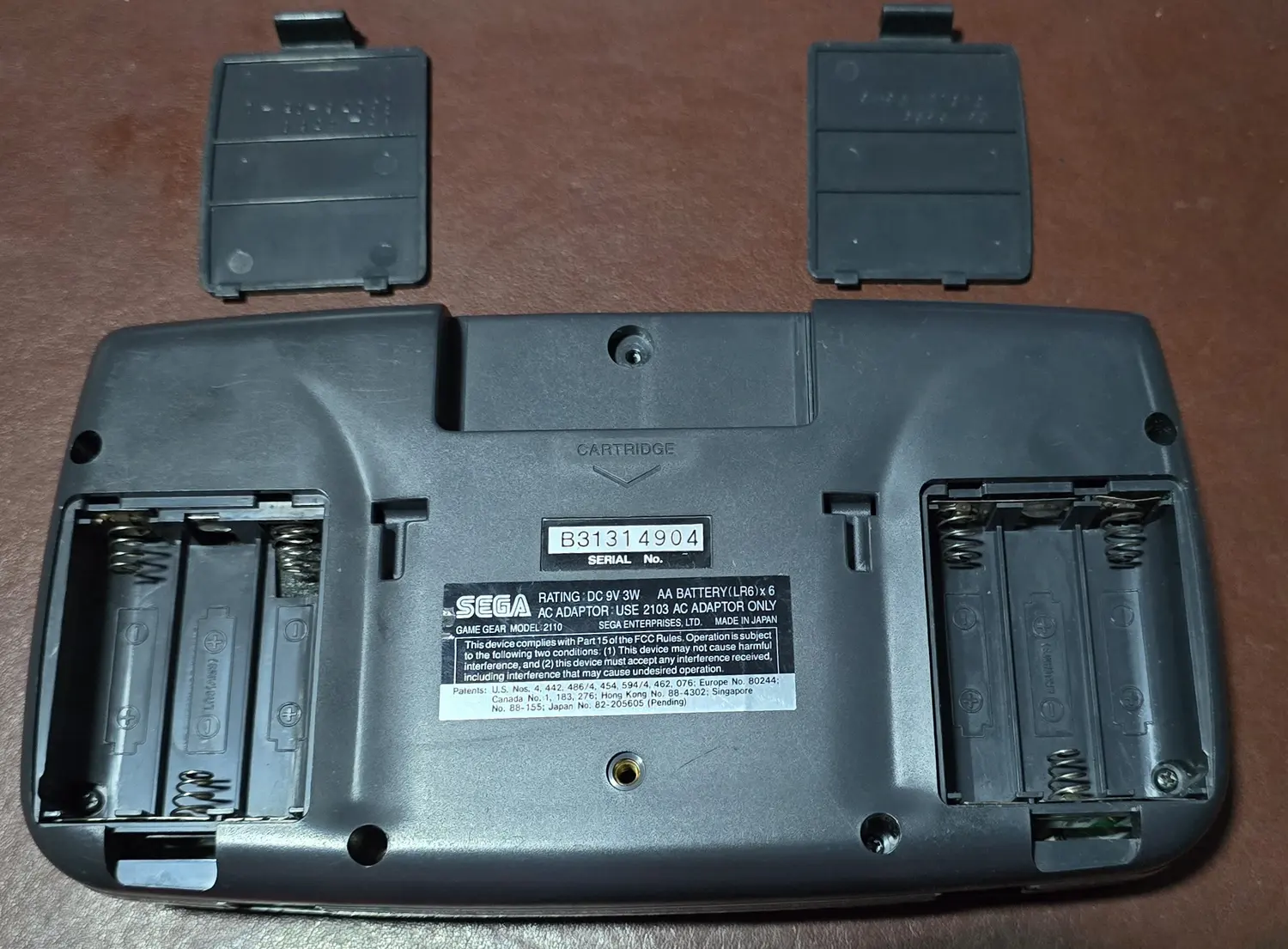 Both battery bays with the original doors removed, showing cleaned contacts and springs
