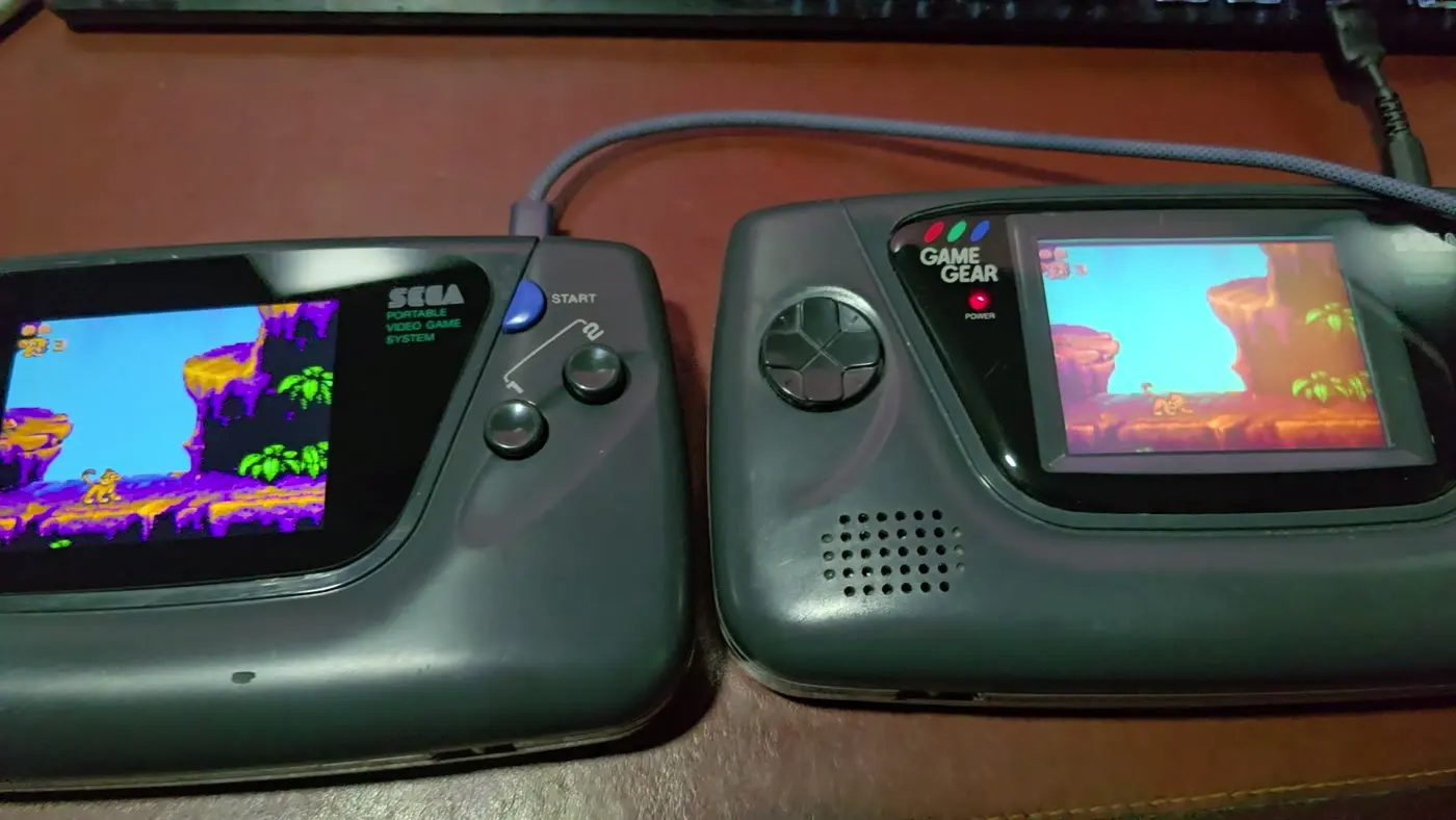 Two Game Gears side by side running The Lion King, the left one on an IPS panel and the right one on its original LCD, showing the difference in colour and clarity