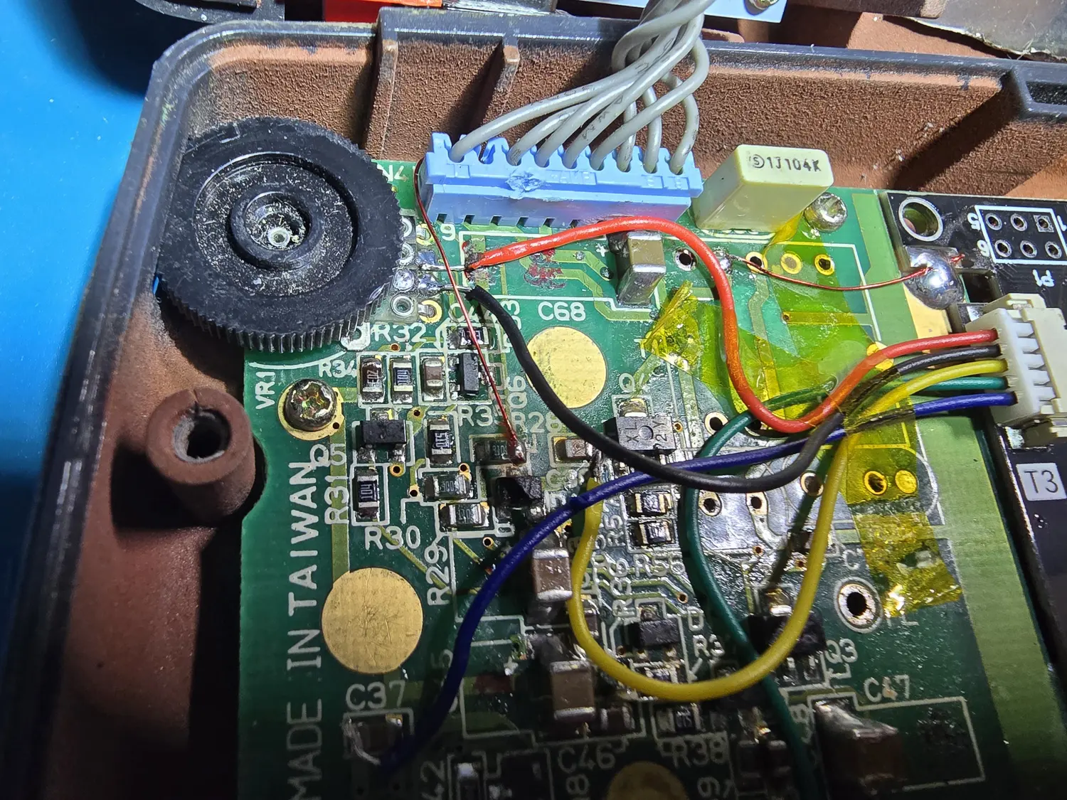 Close-up inside the console: the PowerCore's twisted power pairs into the blue connector and the five-wire IPS harness into its white JST