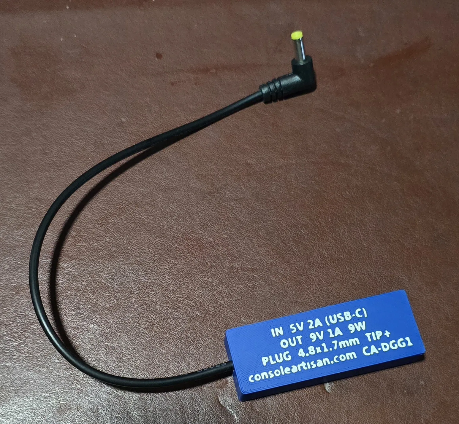 Back label of the Game Gear adapter reading IN 5V 2A USB-C, OUT 9V 1A 9W, plug 4.8x1.7mm tip-positive, model CA-DGG1