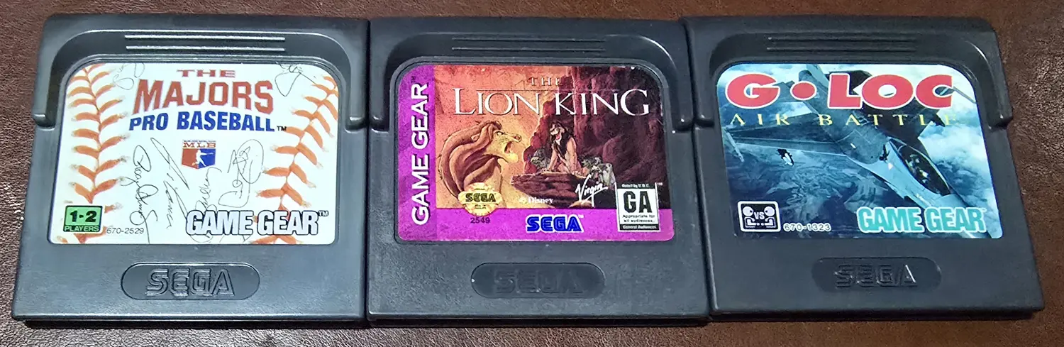 The three included Game Gear cartridges: The Majors Pro Baseball, The Lion King, and G-LOC Air Battle