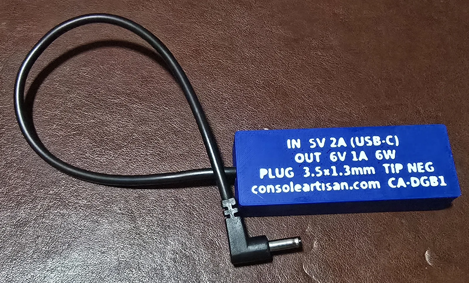 Back label of the Game Boy adapter reading IN 5V USB-C, OUT 6V, plug 3.5x1.35mm centre-negative, model CA-DGB1
