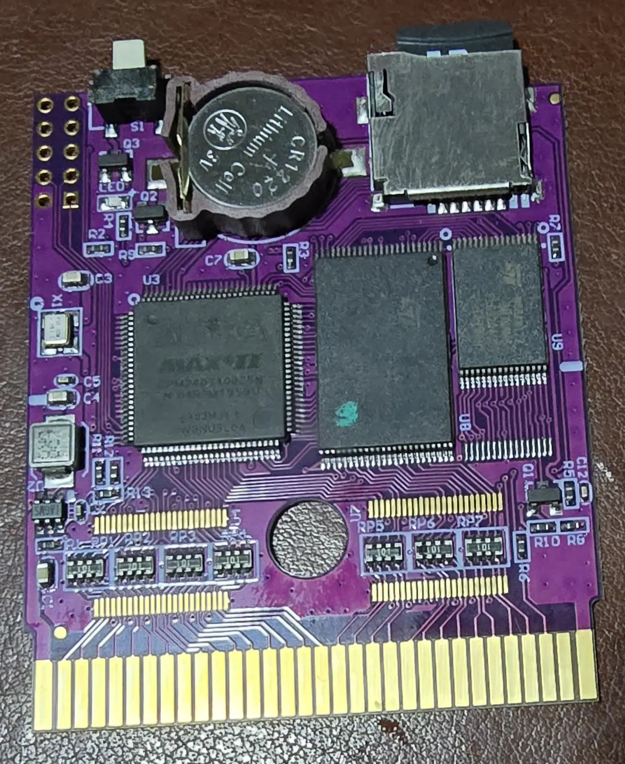 The flash cartridge with its shell open, showing the programmable logic chip, the memory chips and the microSD socket