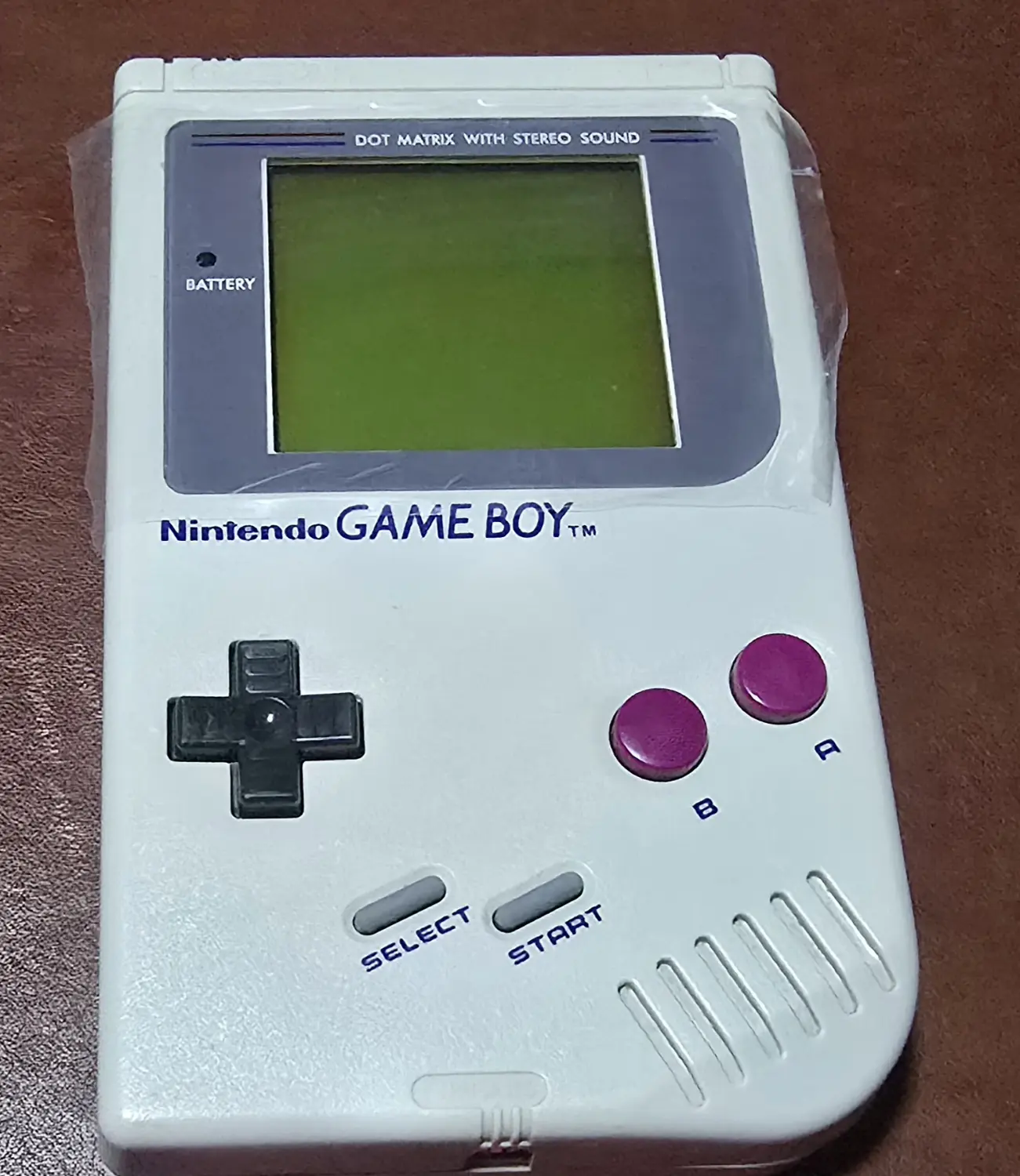 Front of the first restored Game Boy DMG-01, serial G706232507, showing its replacement front lens with the protective film still fitted