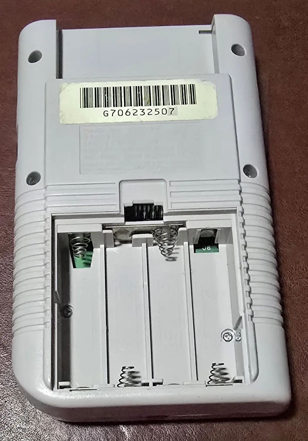 Battery compartment of the first Game Boy with the door removed, showing clean contacts and springs