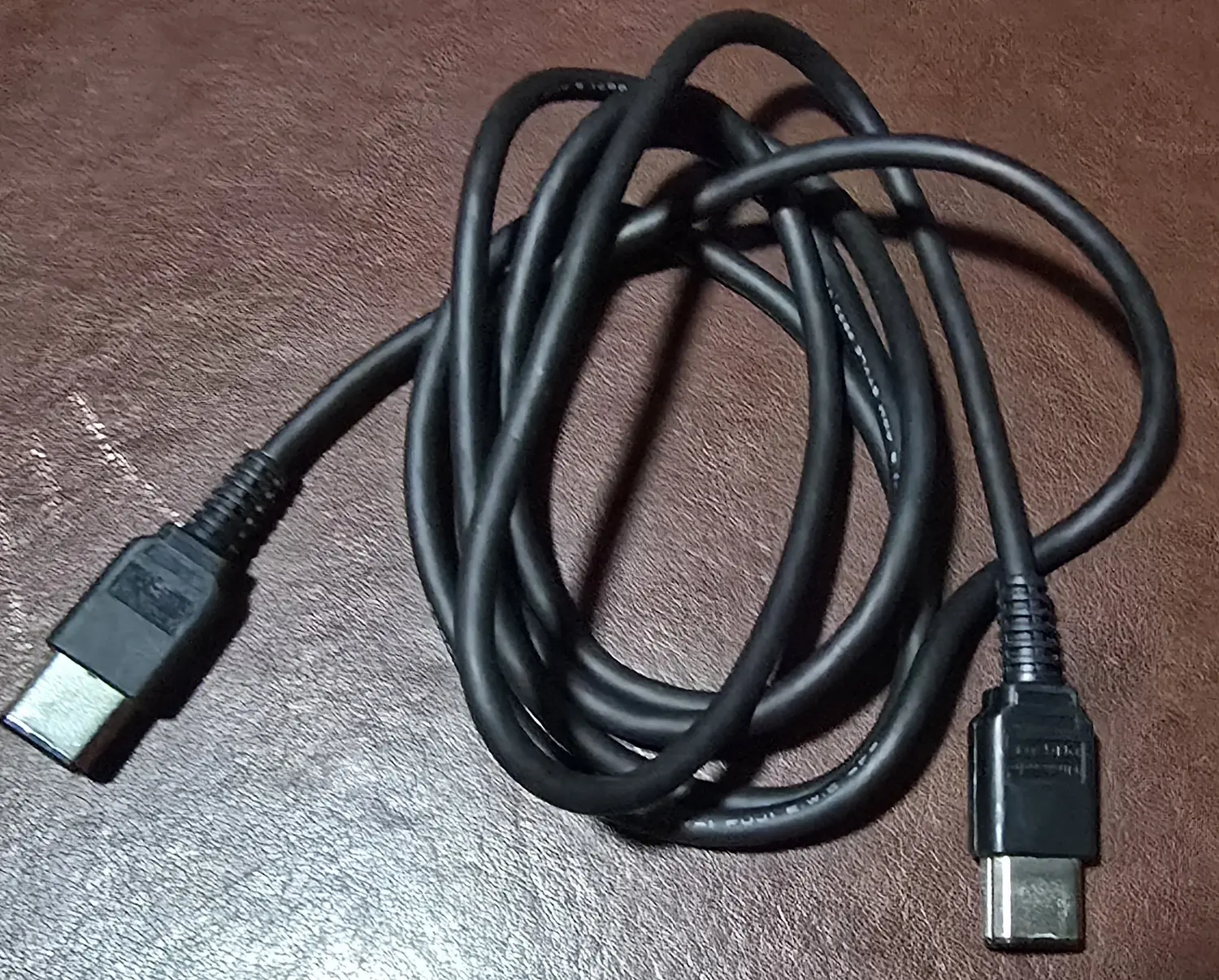 The included Nintendo DMG-04 Game Link Cable coiled, showing the large original-Game-Boy connector on both ends