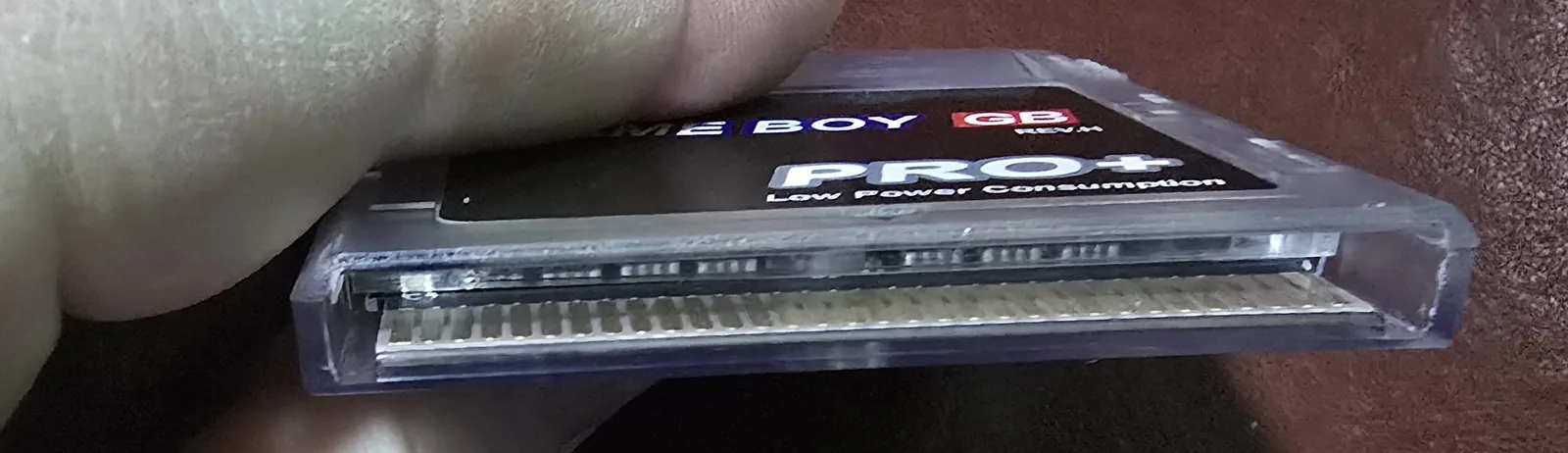Bottom edge of the GB Pro+ flash cartridge showing the gold-plated edge connector pins