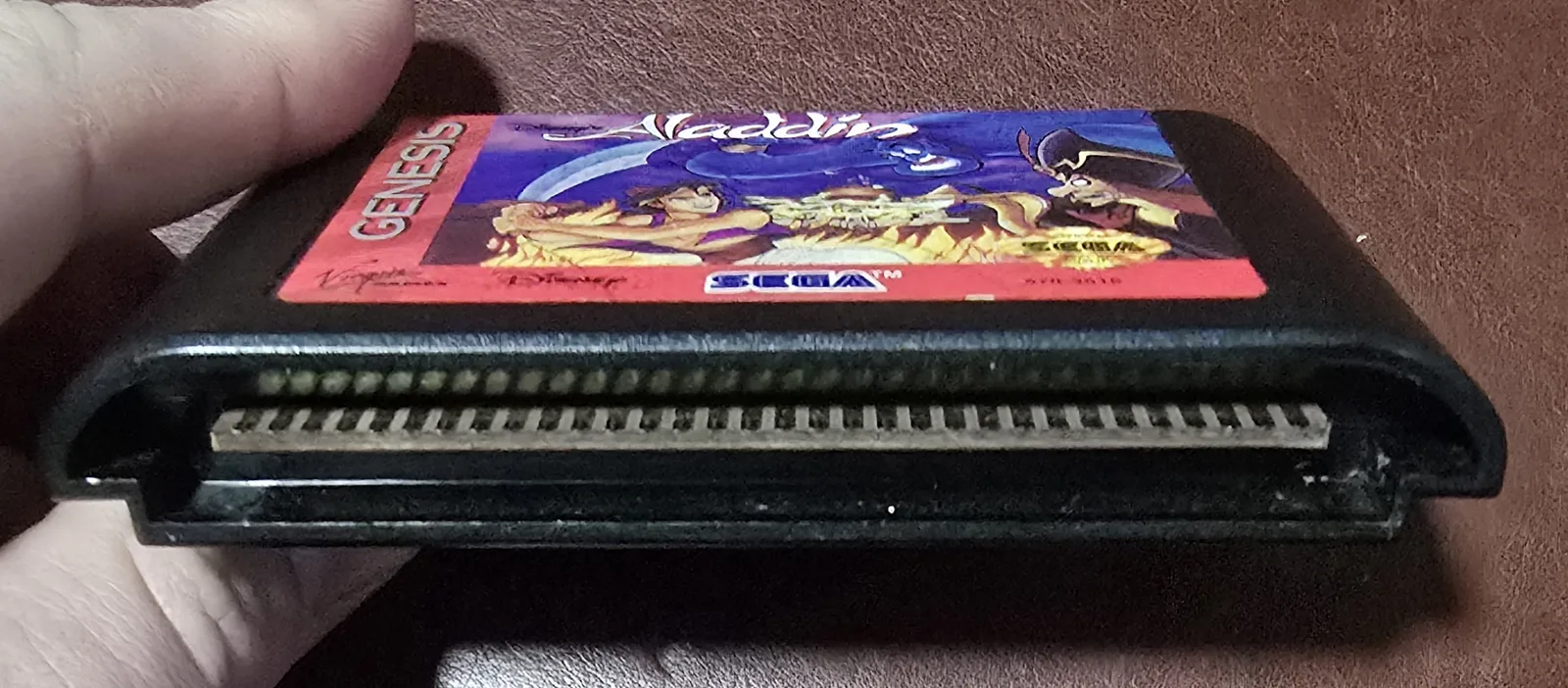 The cartridge's gold edge-connector pins and front label - Virgin Games, Disney, Sega