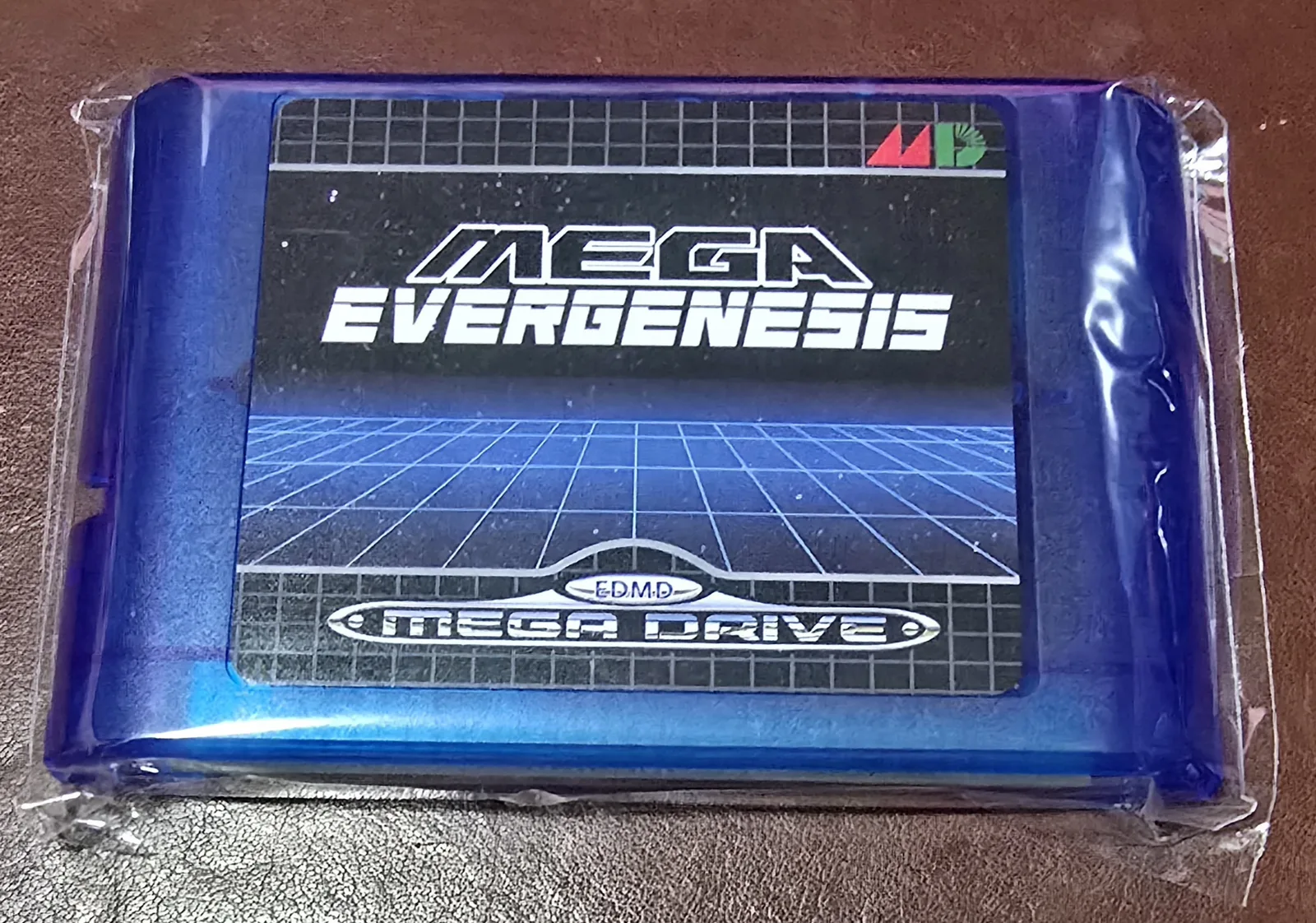Front of a Genesis / Mega Drive microSD flash cartridge in a translucent blue shell with a Mega EverGenesis EDMD Mega Drive label