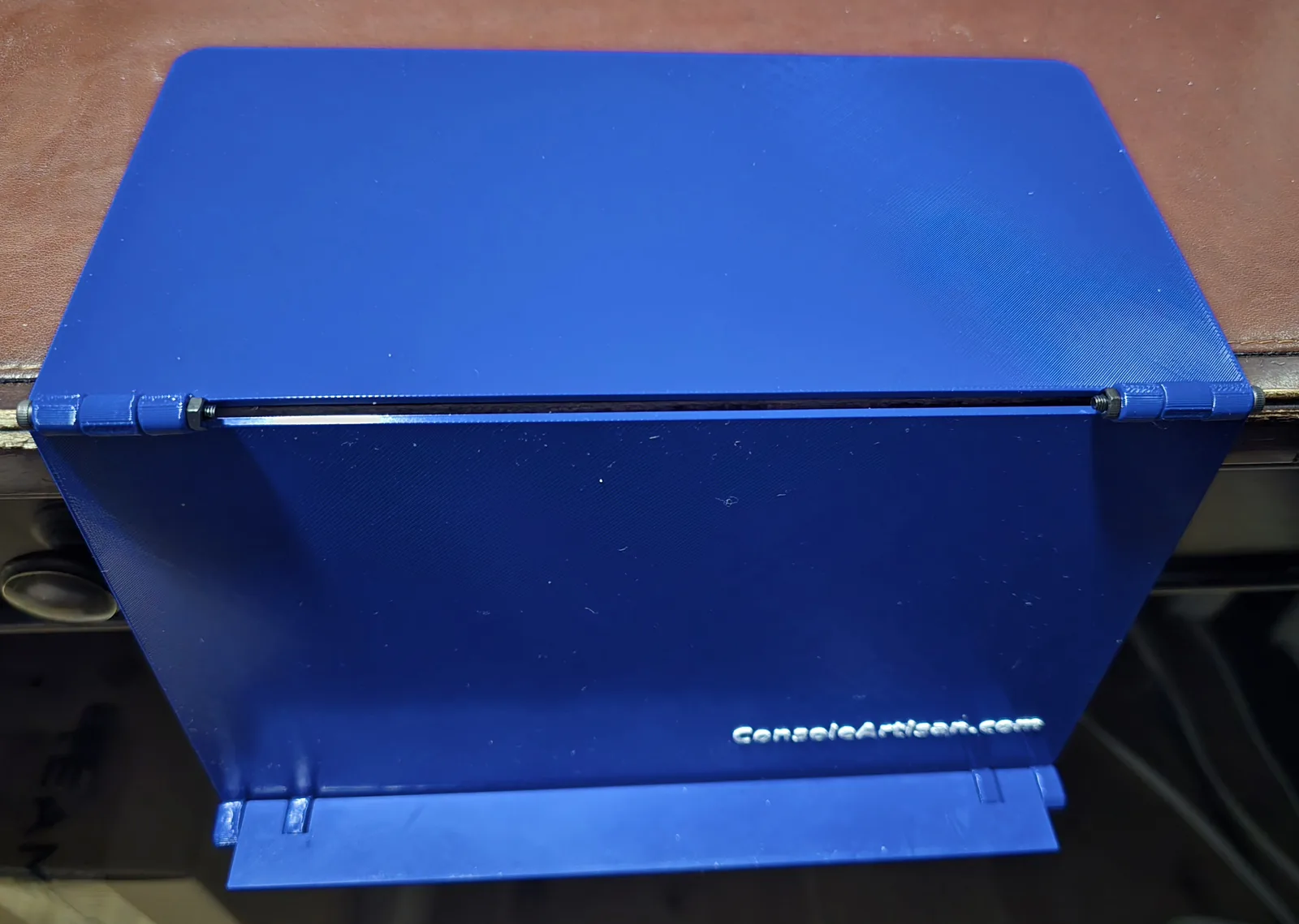 Blue Mahjong card holder hanging off a table edge, the top panel resting on the table and the ledge folded out