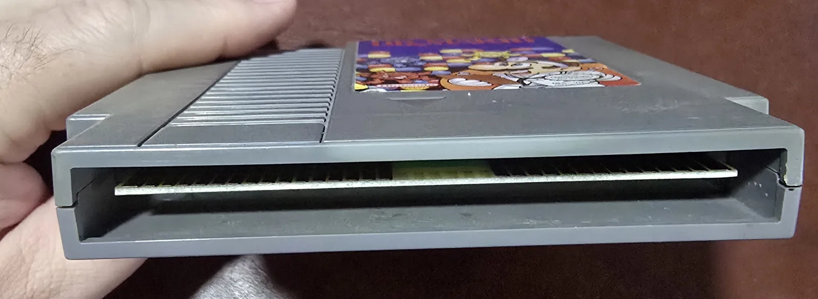 Edge of the Dr. Mario cartridge showing the cleaned gold edge-connector contacts