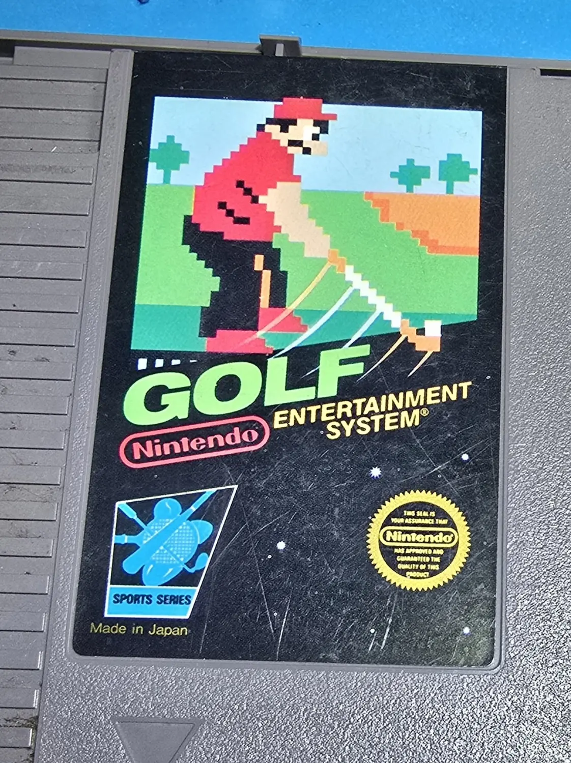 Front label of an authentic Nintendo Golf cartridge for the NES, black box Sports Series design with the pixel golfer in a red shirt