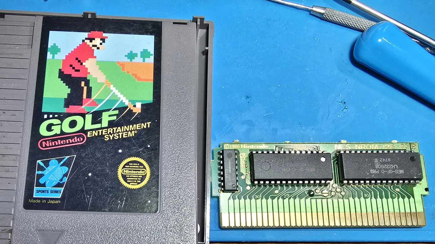 The Golf cartridge shell opened, label half beside the bare circuit board