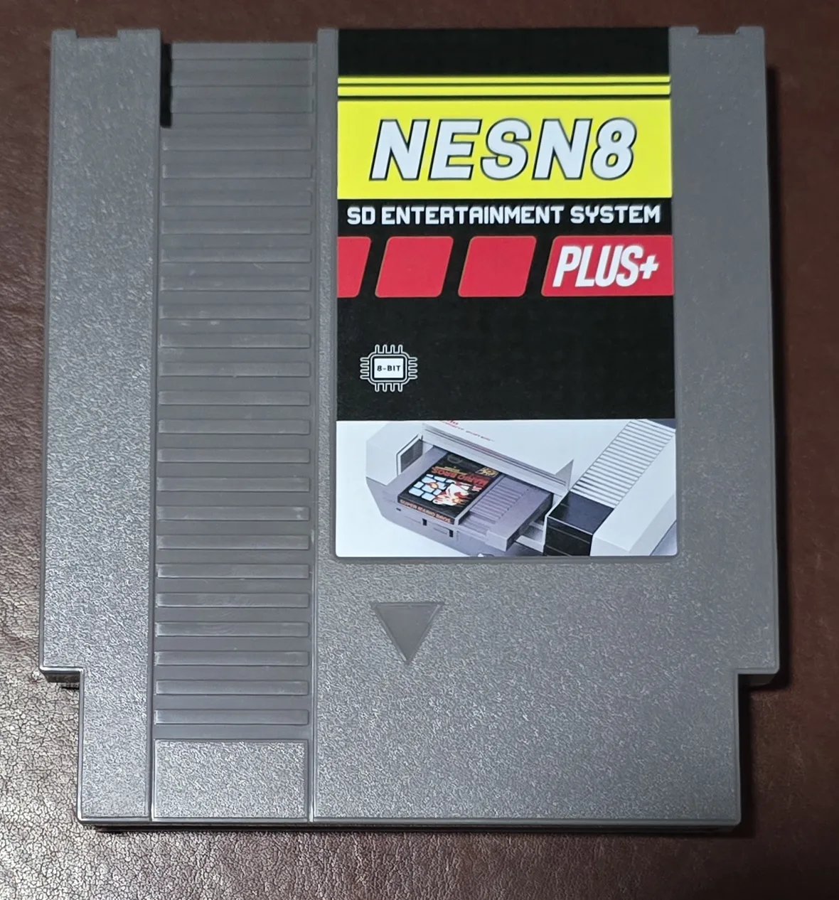 Front of a NES N8 Pro SD flash cartridge in a gray shell with a NESN8 PLUS+ SD Entertainment System label