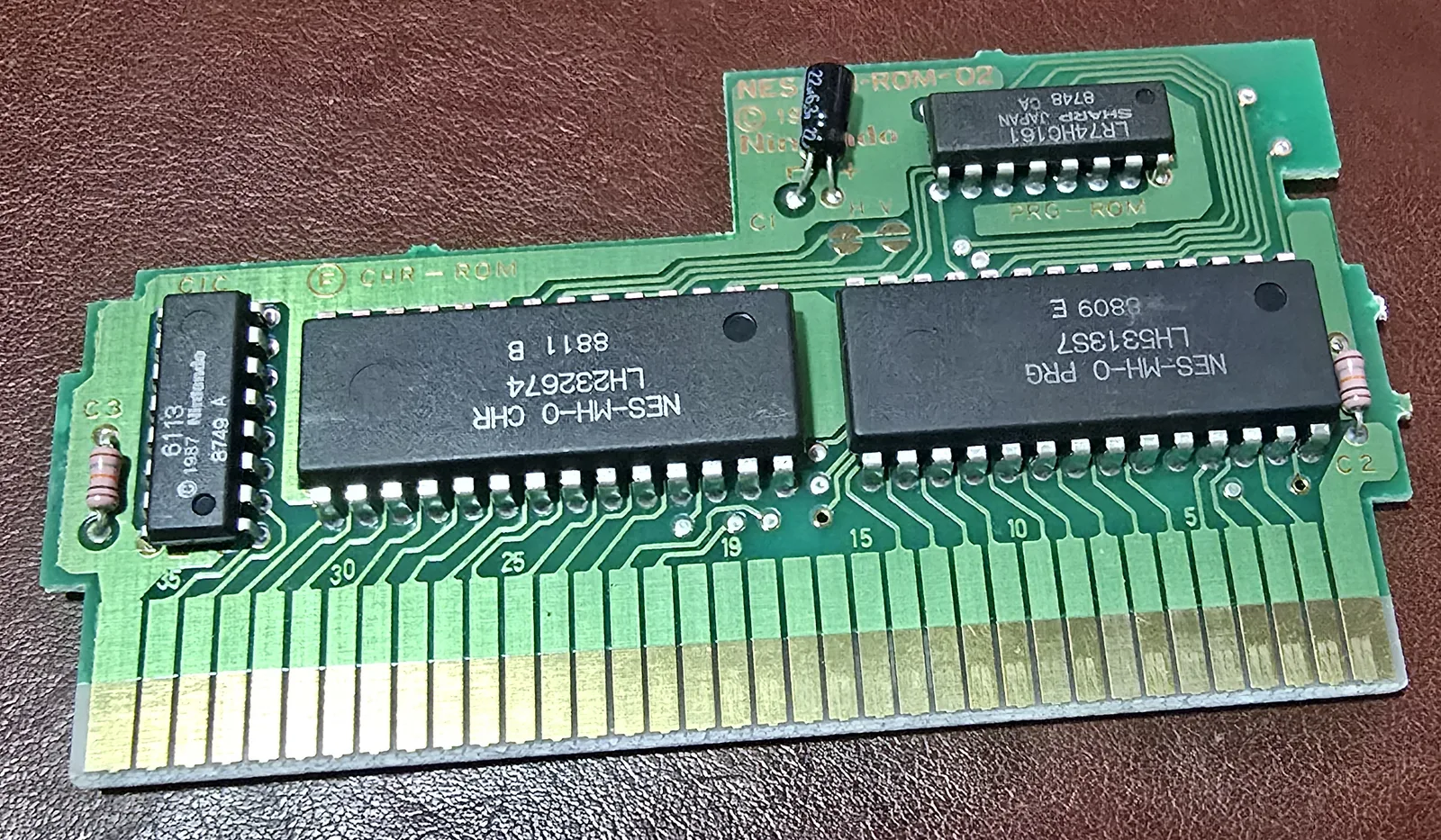 Standard Super Mario Bros. slash Duck Hunt circuit board with packaged Nintendo chips: NES-MH-0 PRG and CHR ROMs, a 74HC161 and the 6113 lockout chip