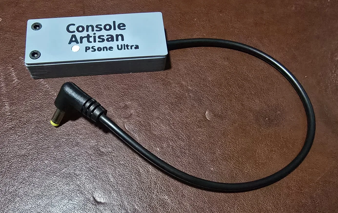 The finished Console Artisan PSone Ultra USB-C power adapter with its right-angle barrel plug and cable coiled beside it