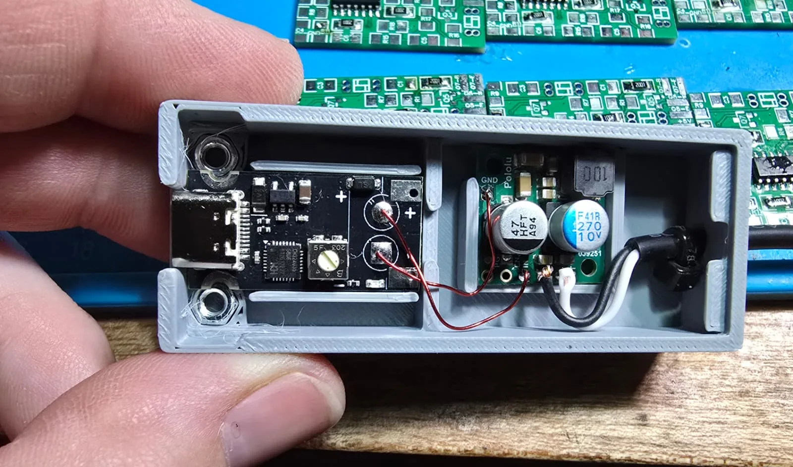 Close-up inside the adapter showing the USB-C trigger board, the buck converter, the wiring between them and the output cable