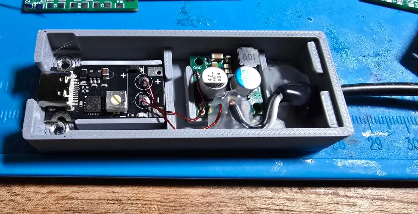 Another interior view of the assembled adapter with a bead of adhesive securing the converter and the output cable