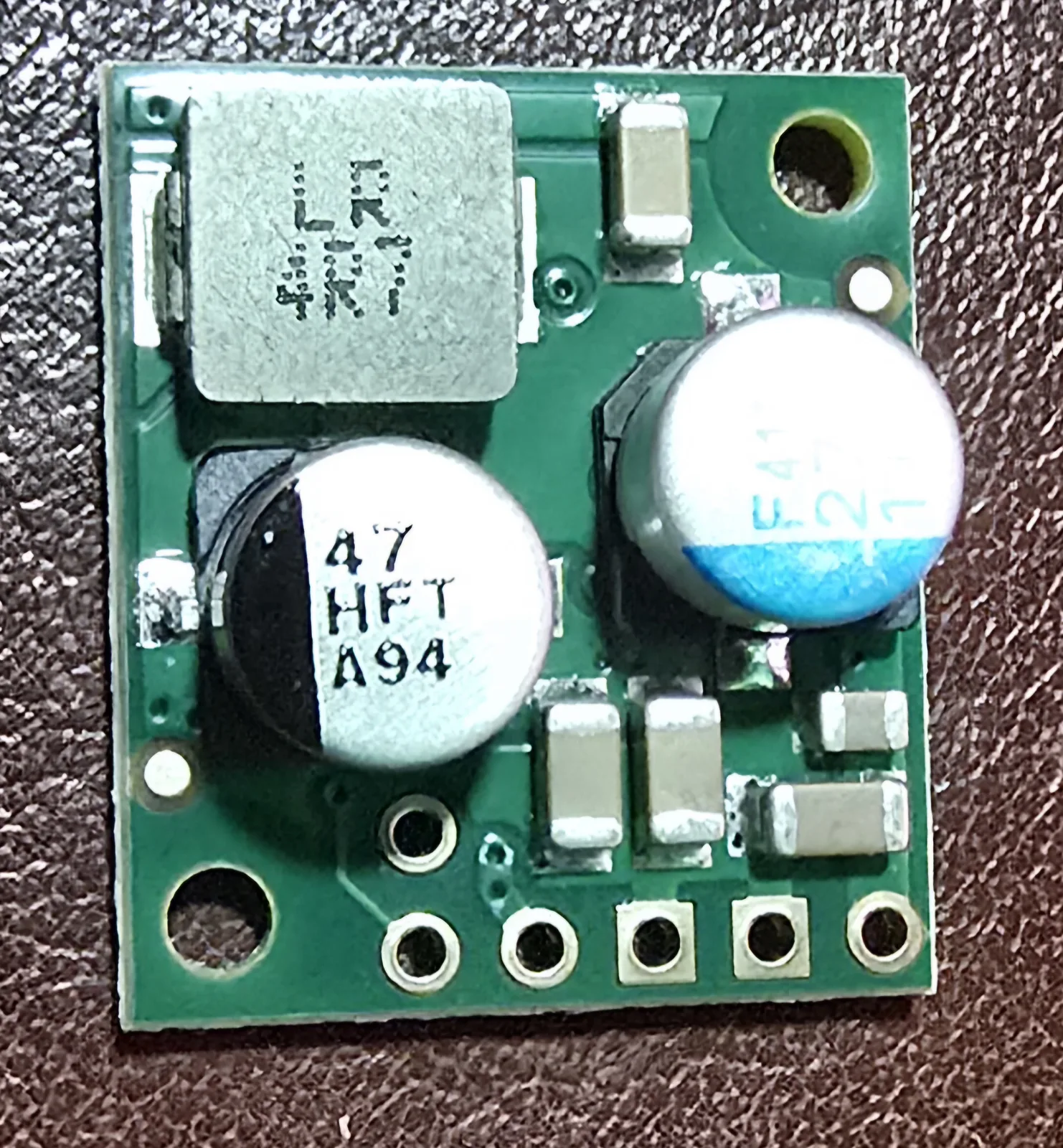Close-up of the Pololu D36V28F7 buck converter board showing its shielded inductor and capacitors