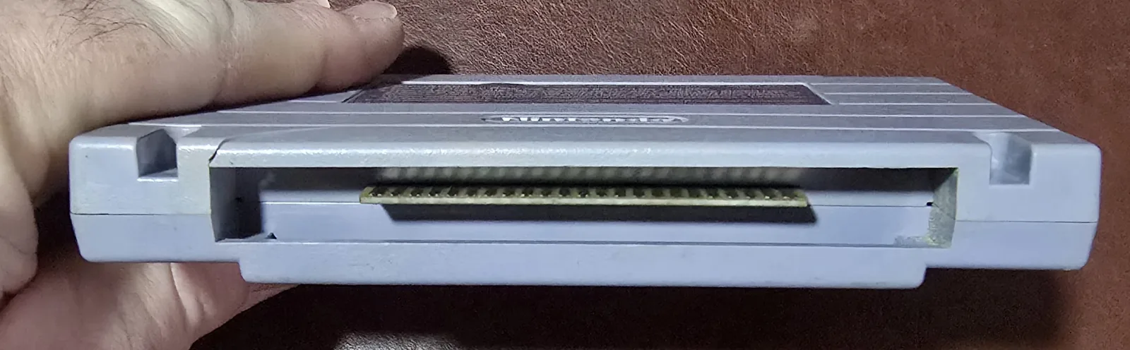 Edge of the SNES Clue cartridge showing the cleaned edge-connector contacts
