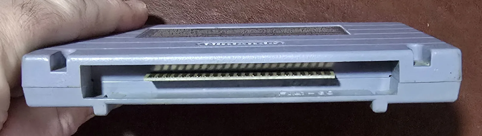Edge of the SNES cartridge showing the cleaned gold edge-connector contacts