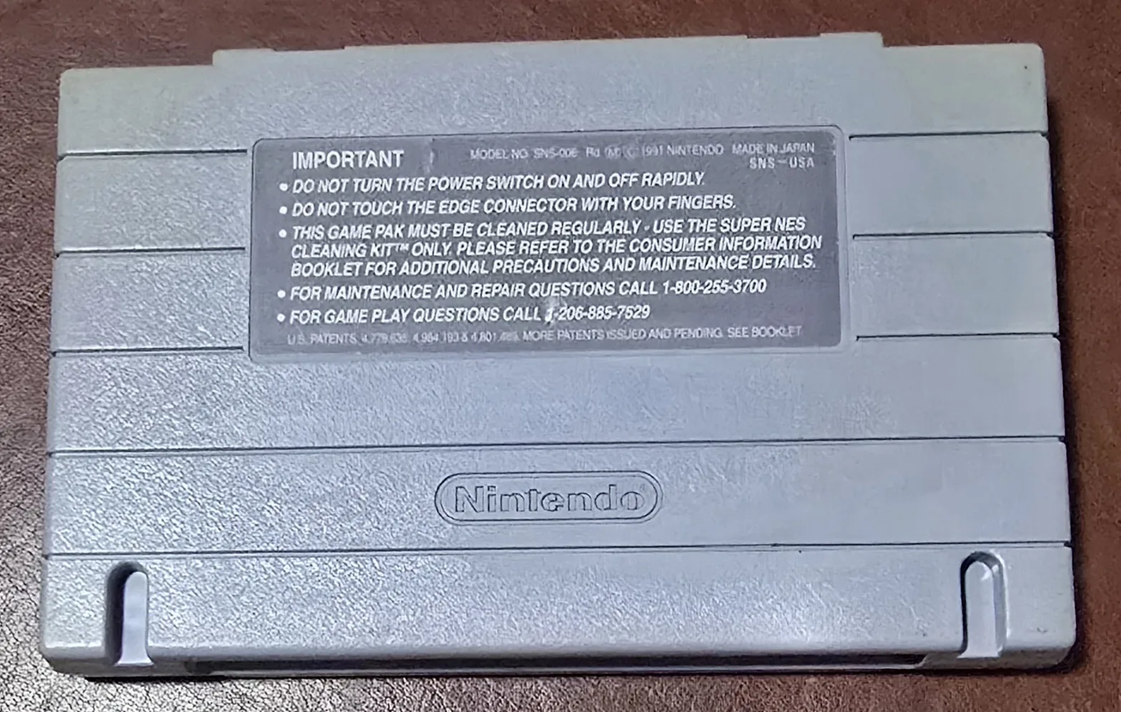 Back of the Nolan Ryan's Baseball SNES cartridge shell with the Nintendo caution label