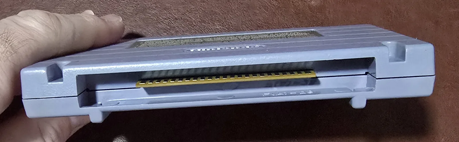 Edge of the SNES cartridge showing the cleaned gold edge-connector contacts