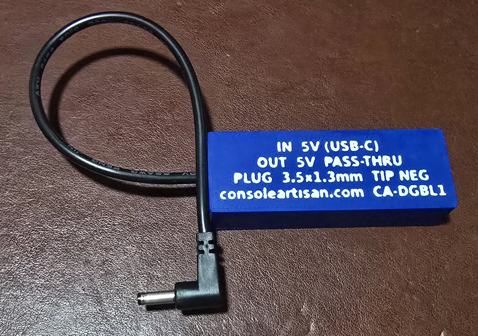 Back label of the DMG Game Boy Lite adapter reading IN 5V USB-C, OUT 5V pass-through, plug 3.5x1.3mm tip-NEGATIVE, model CA-DGBL1