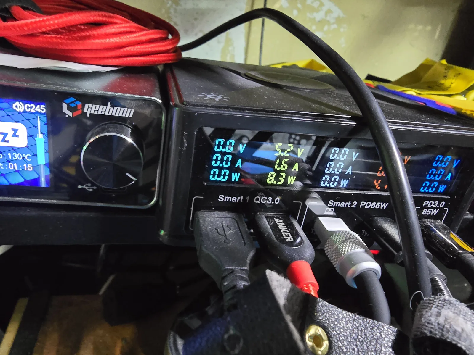 An inline USB power meter reading about 5.2 volts at 1.6 amps on the source side