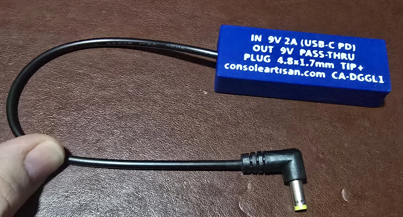 Back label of the Game Gear Lite adapter reading IN 9V 2A USB-C PD, OUT 9V pass-through, plug 4.8x1.7mm tip-positive, model CA-DGGL1