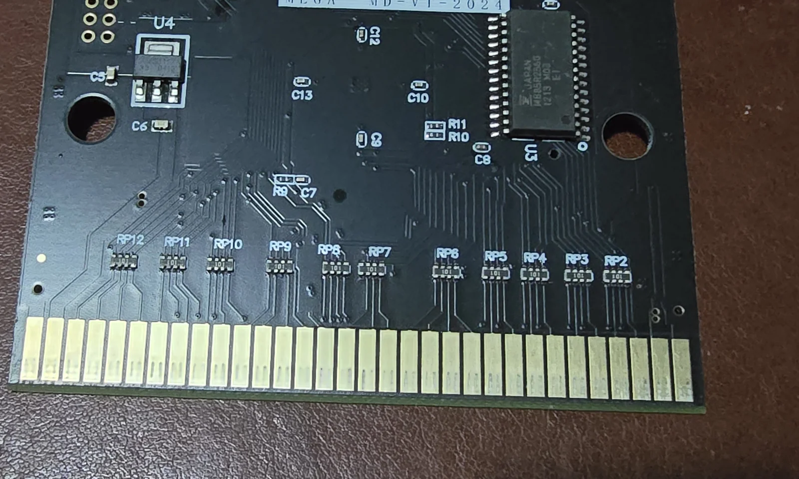 Back of the Mega EverGenesis PCB showing eleven resistor networks labelled RP2 through RP12, each marked 101, in a row above the card edge connector with traces fanning out to each finger.