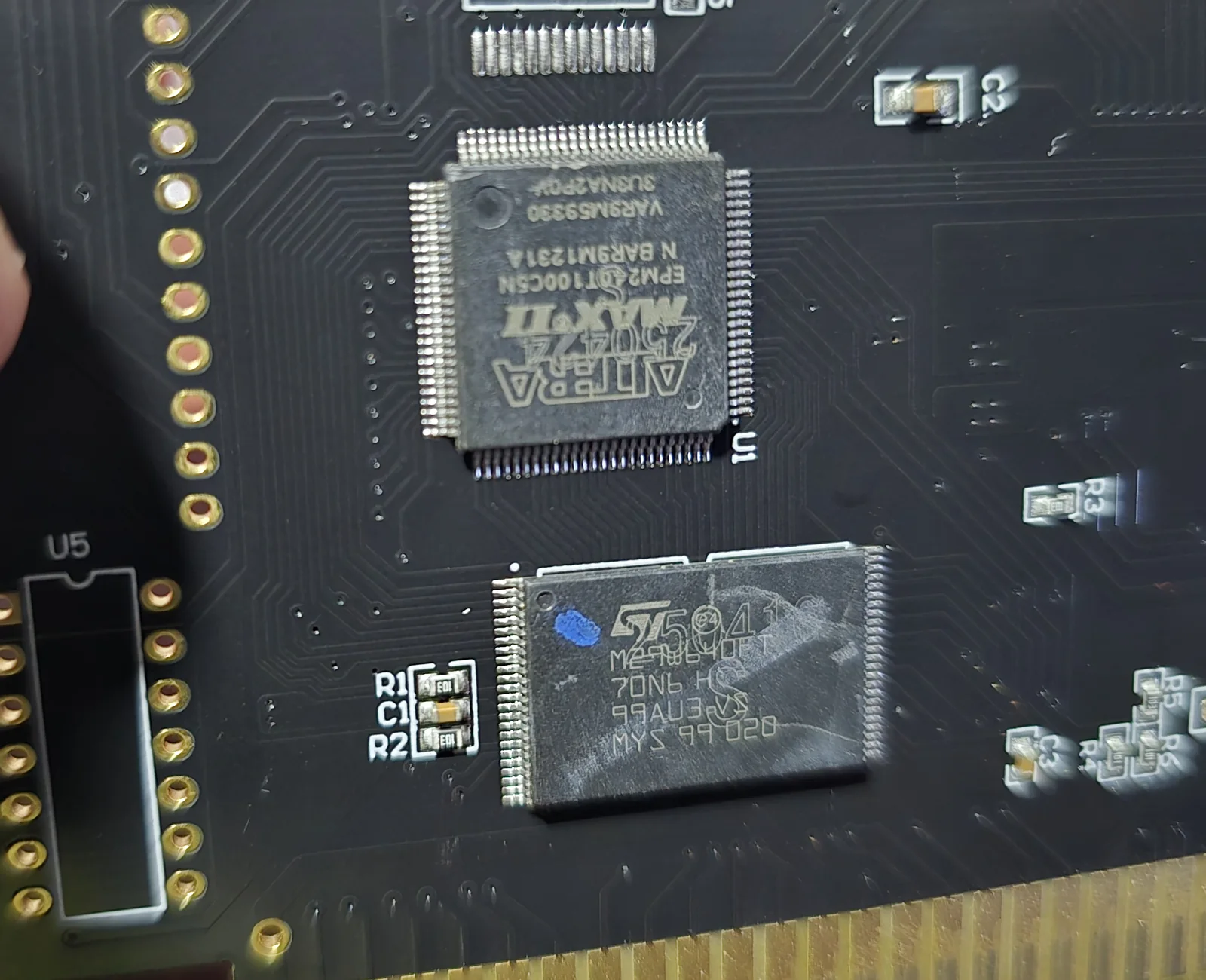 Close-up of the FlashMaster front side showing an Altera MAX II EPM240T100C5N CPLD in a 100-pin package and an ST M29W640FT flash chip in TSOP, with an unpopulated DIP footprint labelled U5 to the left.