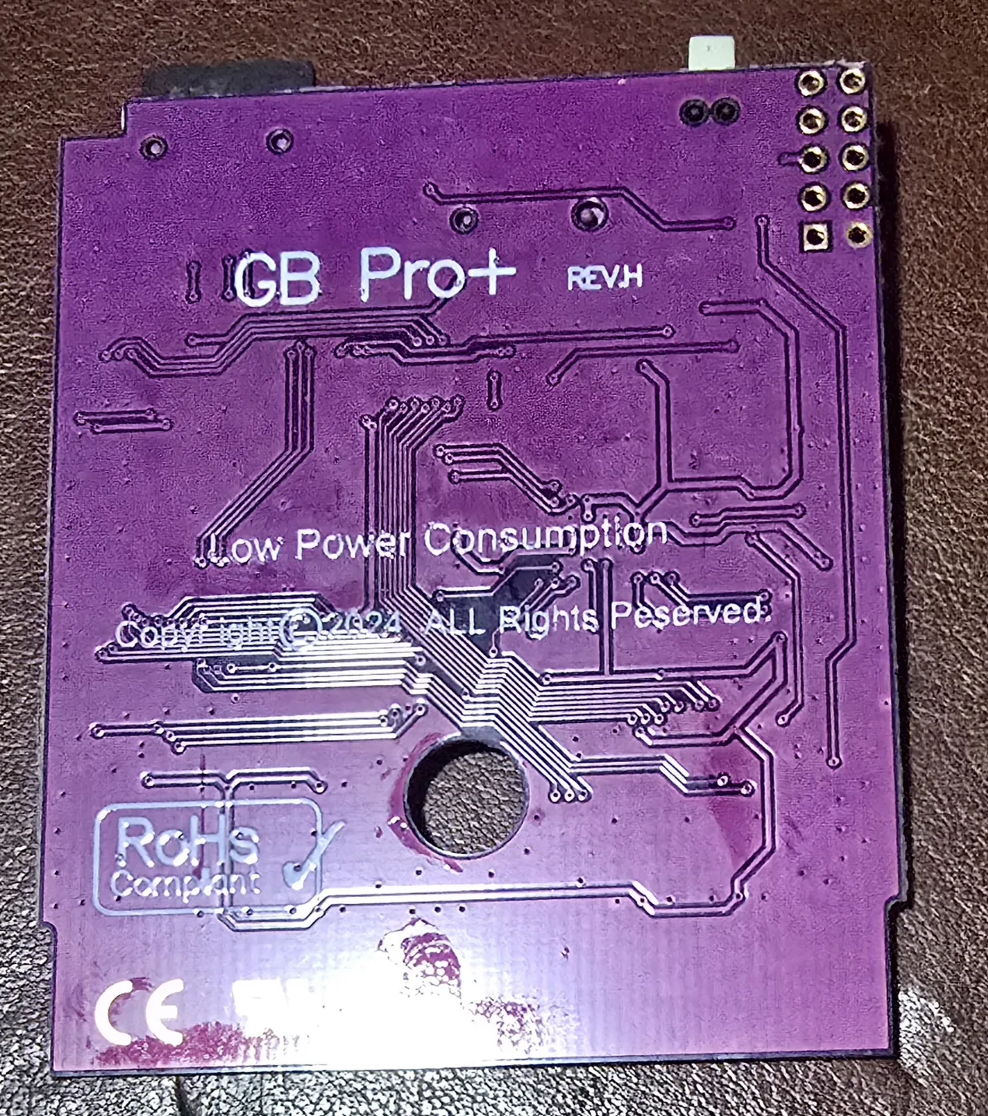 Solder side of the GB Pro+ cartridge board, bare of components, with white silkscreen reading GB Pro+ REV.H, Low Power Consumption, Copyright 2024 ALL Rights Reserved, RoHs Compliant and CE.