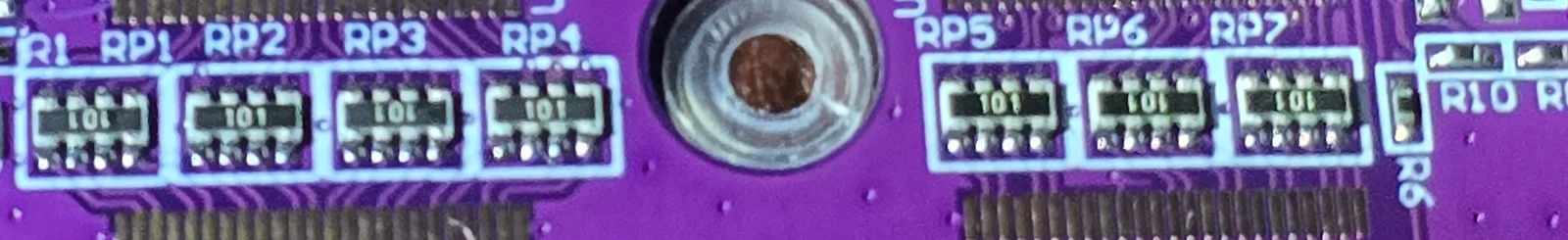 Close-up along the edge connector of the GB Pro+ board showing seven four-element resistor networks labelled RP1 to RP7, split four and three either side of the shell screw hole, every one marked 101.