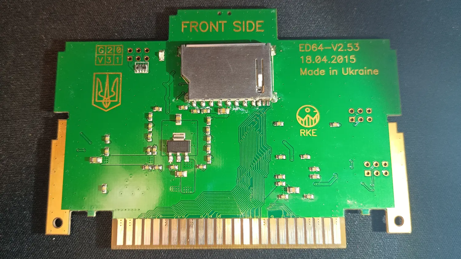 EverDrive 64 PCB front side, whole board, silkscreened ED64-V2.53 18.04.2015 Made in Ukraine with a Ukrainian trident, showing an SD card slot, an AMS1117 regulator, and the N64 card edge connector, with no transceivers anywhere on the board.