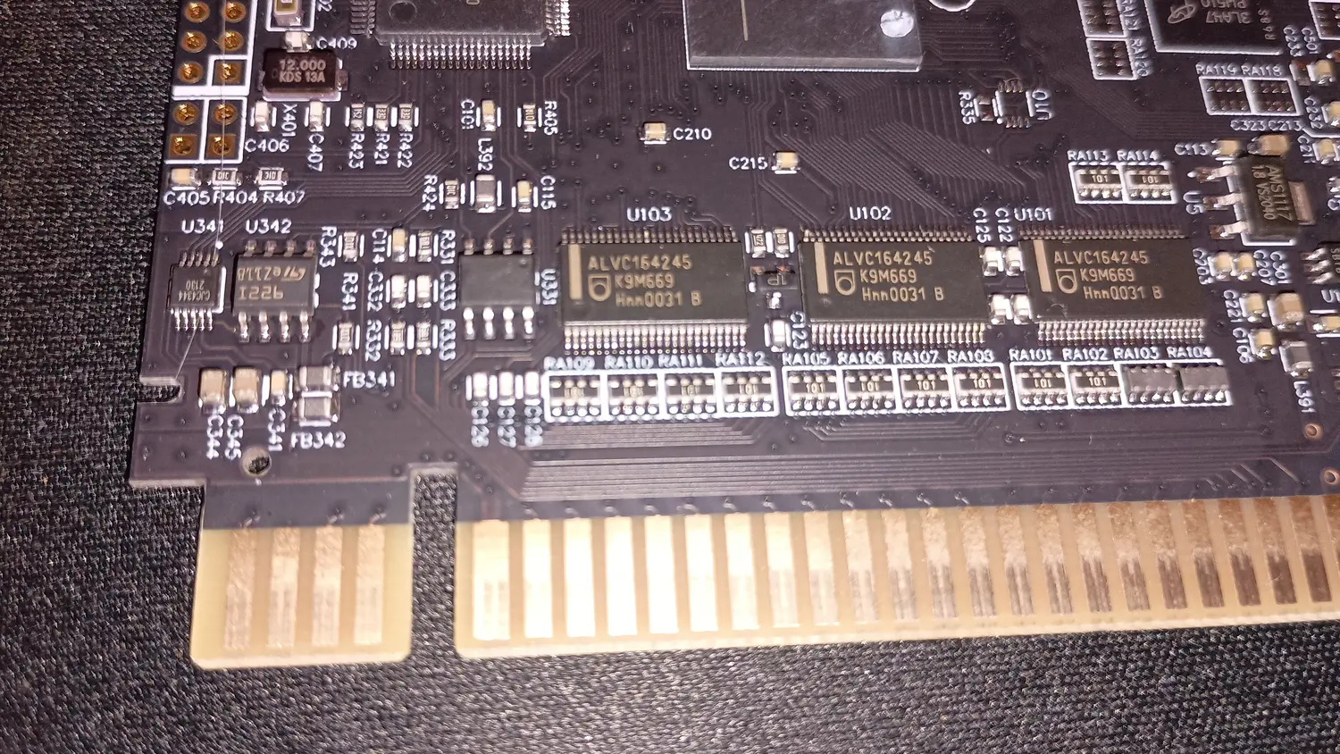 Component side of the KY Technology SD2SNES clone PCB above the card edge connector, showing three 48-pin transceivers at U101, U102 and U103 each marked ALVC164245 K9M669, with resistor networks marked 101 below them.