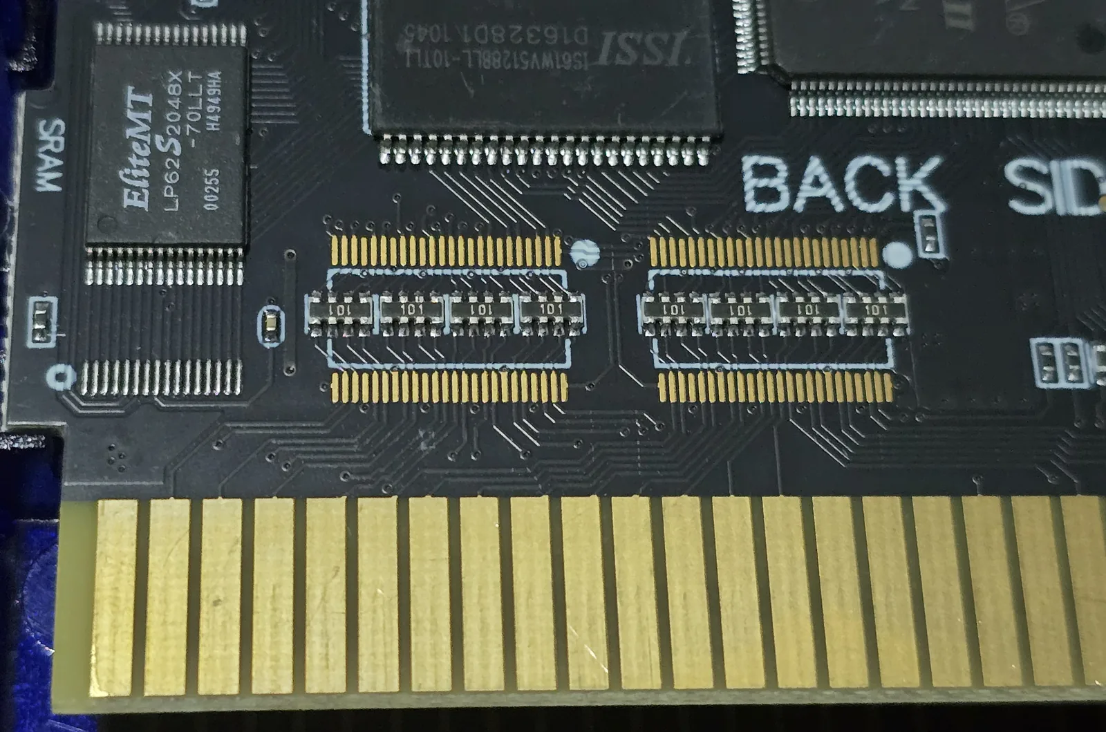 Back side of an EverDrive N8 clone cartridge PCB, showing two bare fine-pitch IC footprints each fitted with four small resistor networks marked 101, sitting between the card edge connector and the memory chips.