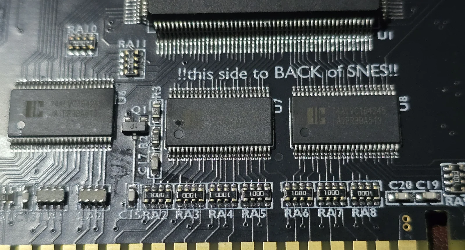 Close-up of the SD2SNES board showing three 74ALVC164245 transceivers labelled U6, U7 and U8 in a row, with resistor arrays RA2 through RA8 marked 1000 beneath them, immediately above the card edge connector.
