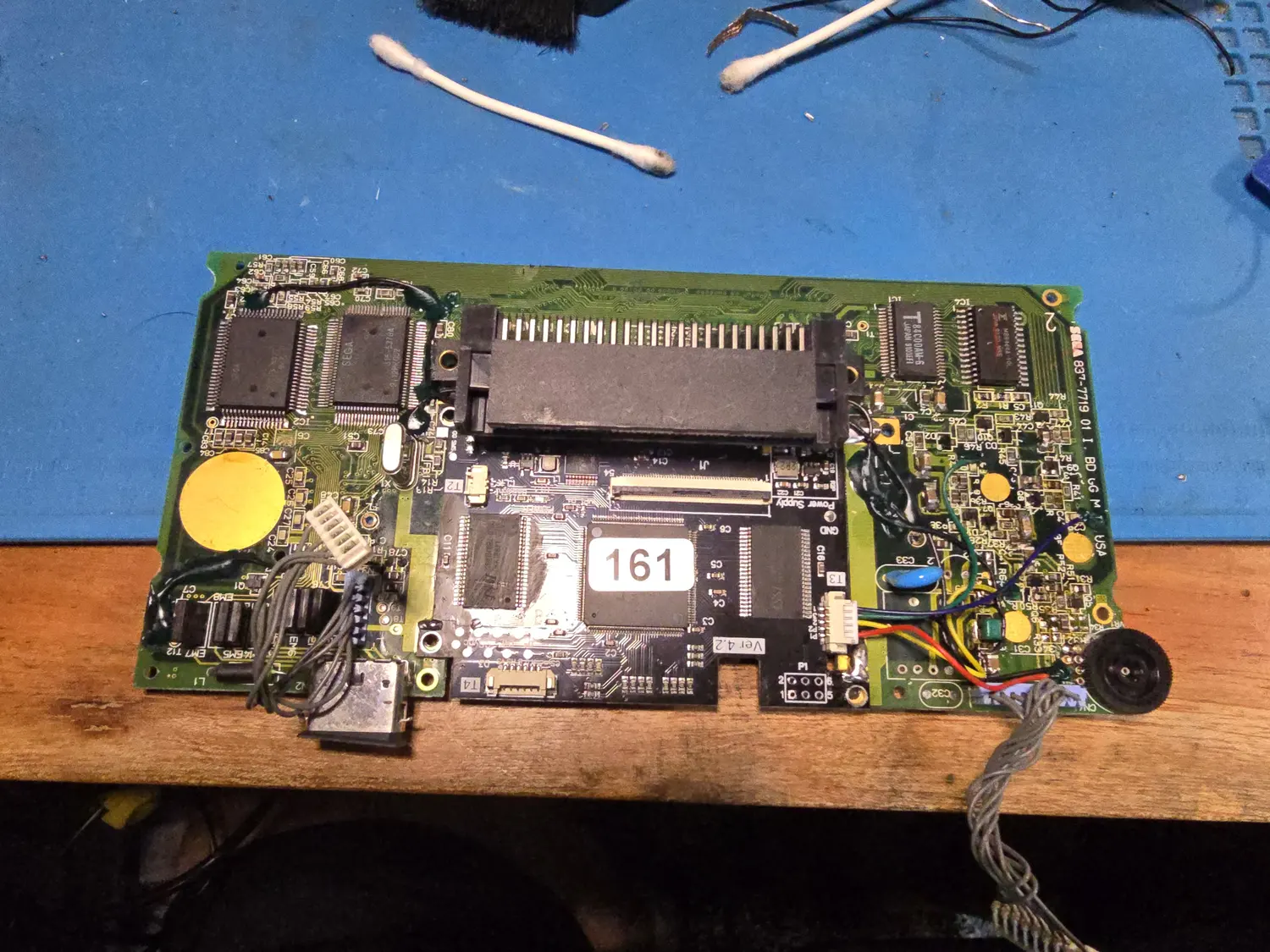Component side of a Game Gear main board silkscreened SEGA 837-7719 01 I. BD GG M T USA, with the FunnyPlaying kit board mounted across the centre and marked Ver 4.2, Power Supply and GND. Two large Sega custom QFPs sit at the upper left, one marked 315-5378A, beside a Toshiba 84C00AM-6 Z80 and an MB8464A RAM at the upper right. Hand-soldered green, blue, yellow, red and black flying leads run from the kit across the right-hand side of the board to a white connector and the speaker, and a grey ribbon leaves the lower right.