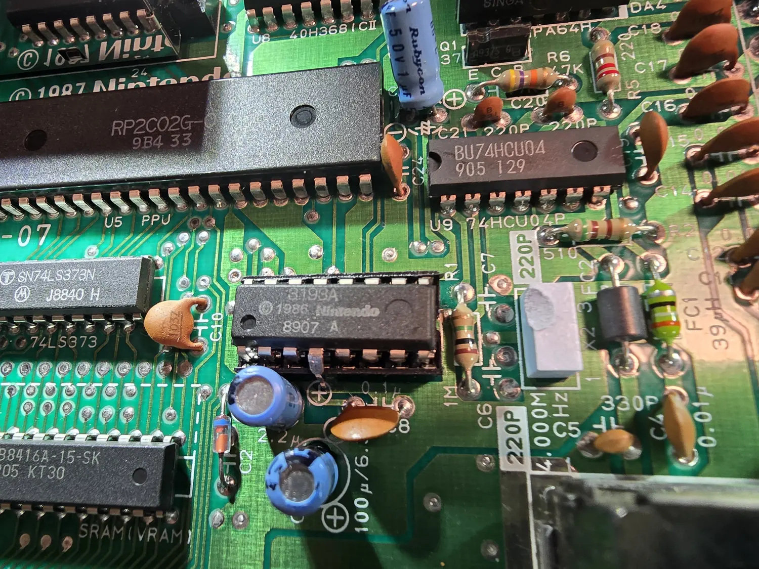 Close-up of an NES mainboard around the lockout chip, a 16-pin DIP marked 3193A with a 1986 Nintendo copyright. The chip sits in a machined socket and one of its legs is bent outward so it stands clear of the socket contact instead of entering it. Surrounding parts include an RP2C02G-0 PPU, an SN74LS373N, a BU74HCU04 at U9, a Rubycon electrolytic, and silkscreen reading 4.000MHz and 1M near a crystal.